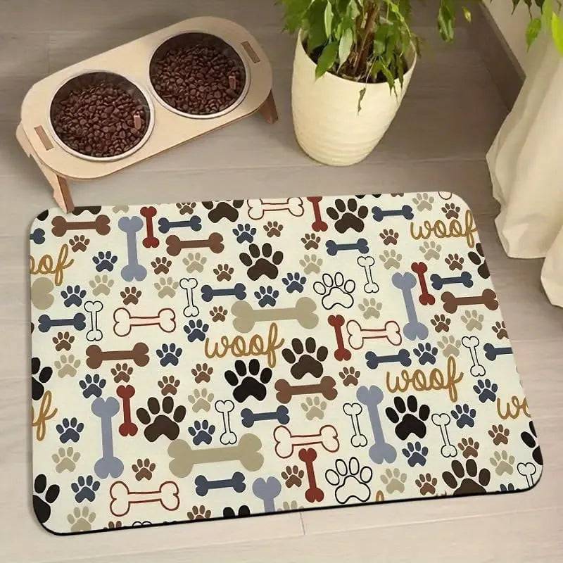 Cream absorbent pet feeding mat printed with woof lettering, bones and paws under a raised double bowl.