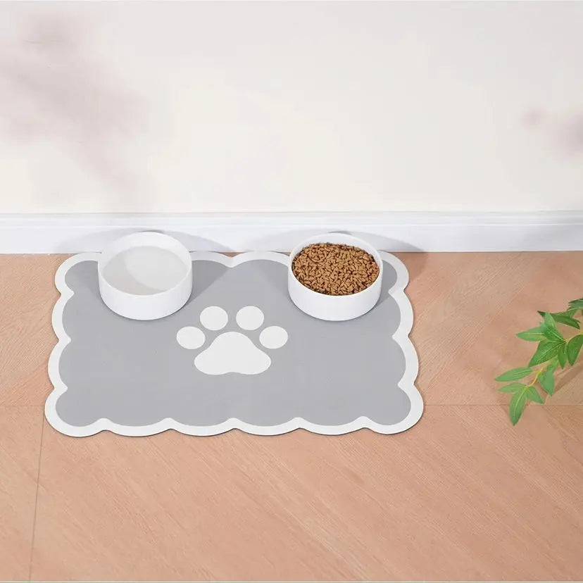 Cloud-shaped gray absorbent pet feeding mat with a white paw print, a water bowl and a food bowl.