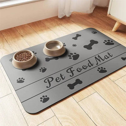 Gray absorbent pet feeding mat printed Pet Food Mat with black bones and paws, holding a food bowl and a water bowl.