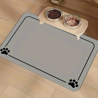 Light gray absorbent pet feeding mat with a thin border line and paw prints in two corners under a raised double bowl.