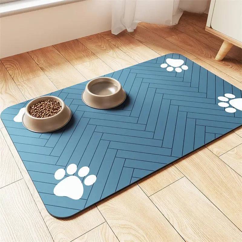 Navy blue chevron absorbent pet feeding mat with white paw prints, a food bowl and a water bowl.