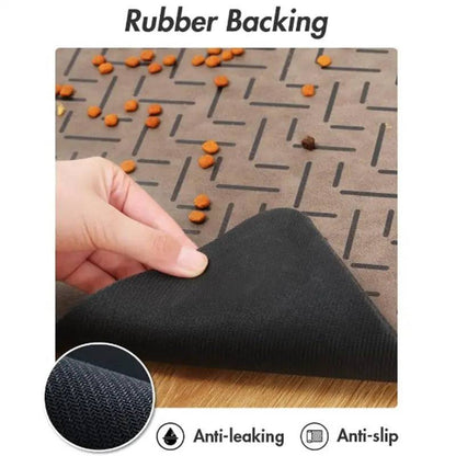 Hand peeling back the taupe chevron mat to show the black anti-leaking, anti-slip rubber backing, with kibble on top.