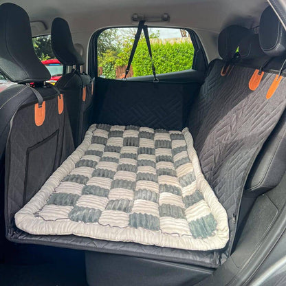 The Noblias back seat dog bed mat in the cream check style, seen from the open car door.