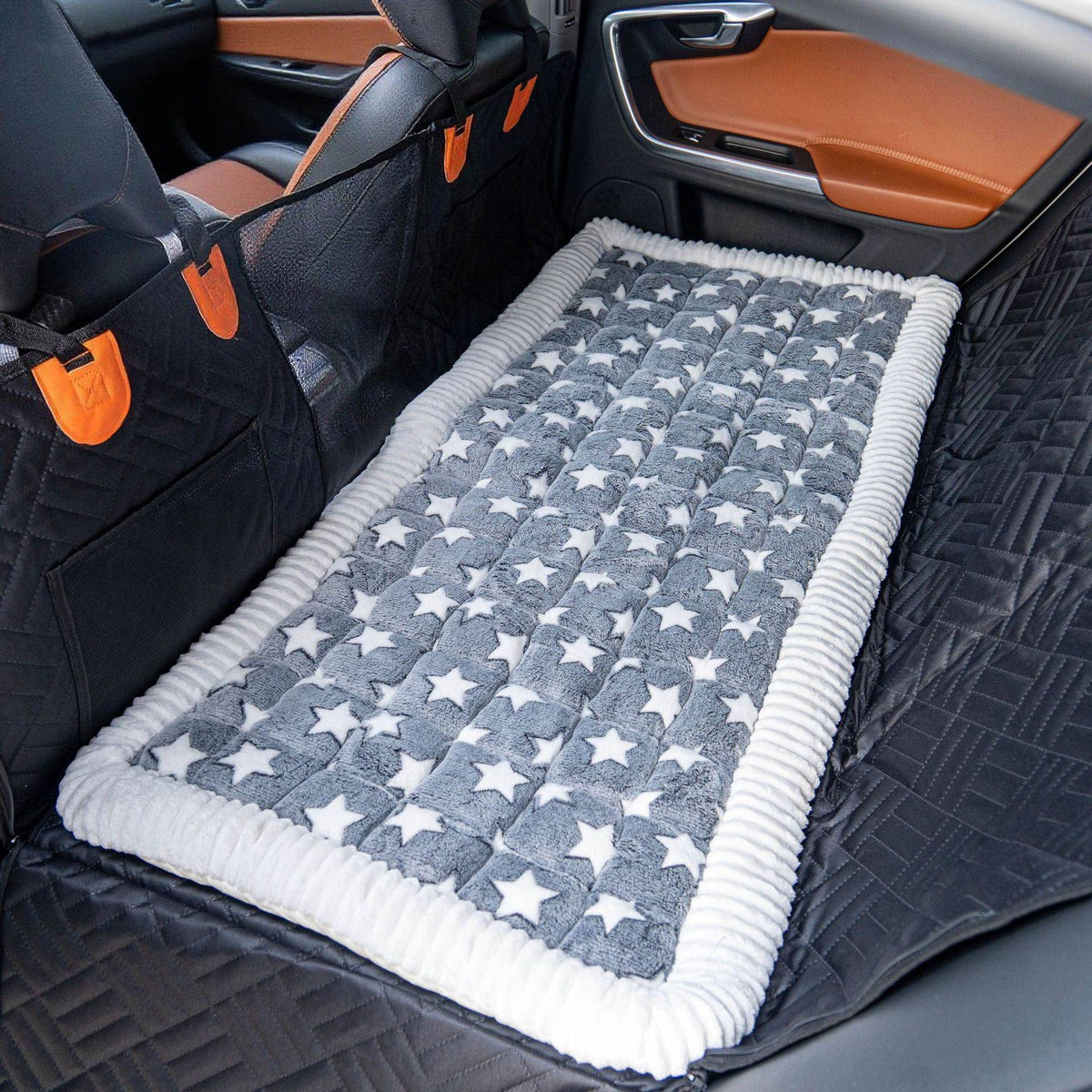The Noblias back seat dog bed mat in the gray star style, laid across the rear seat.