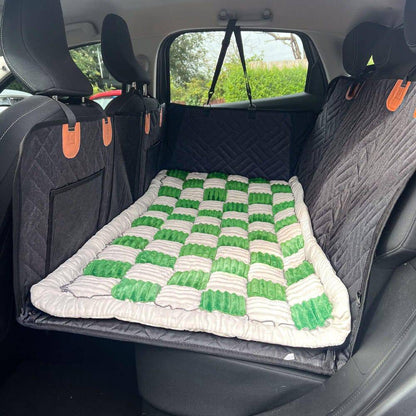 The Noblias back seat dog bed mat in the green check style, laid across the rear seat.