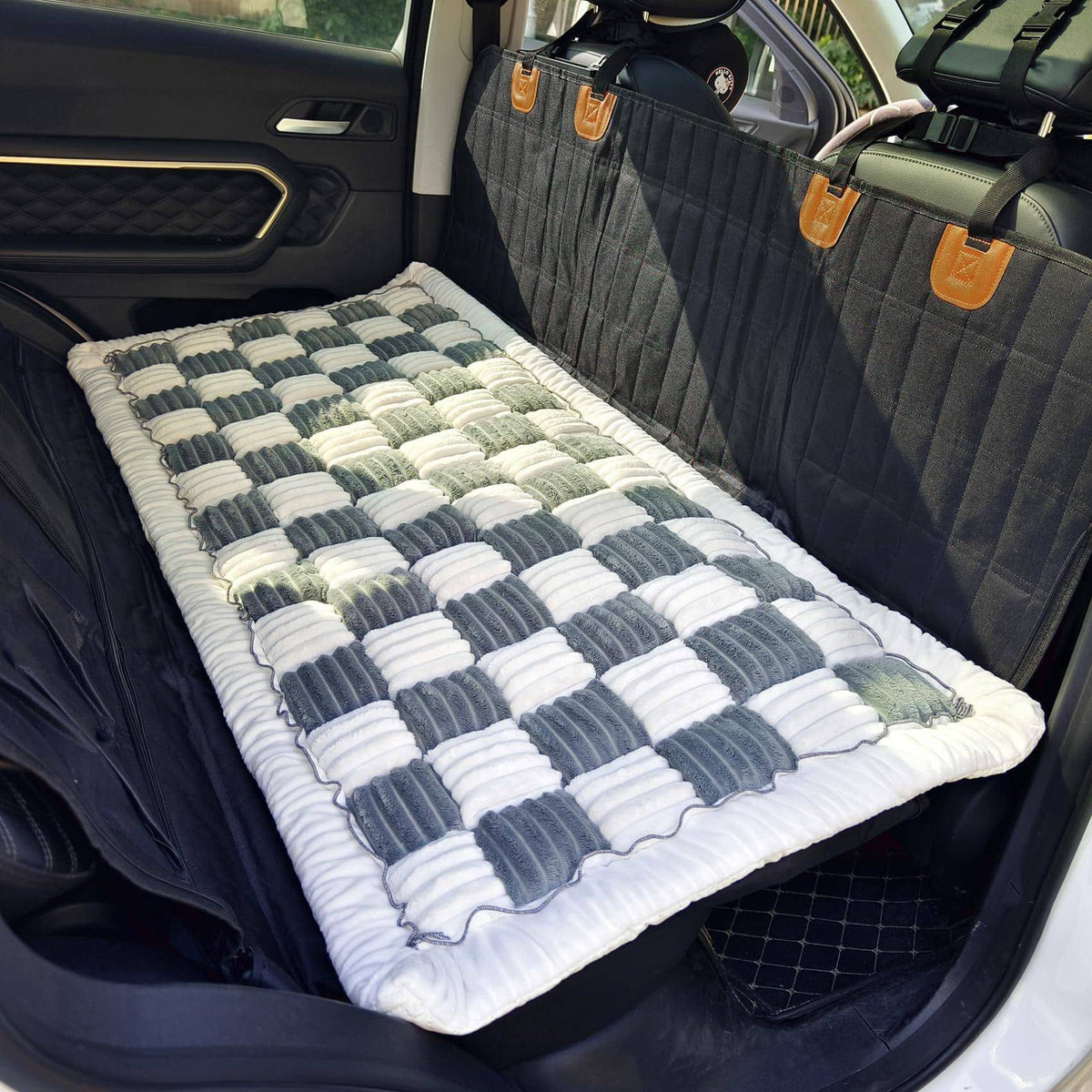 The Noblias back seat dog bed mat laid out on an empty rear bench, showing how far it spreads.