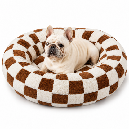 French bulldog lying in the brown checkerboard calming donut dog bed.