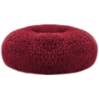 Burgundy red long faux fur donut dog bed on a white background