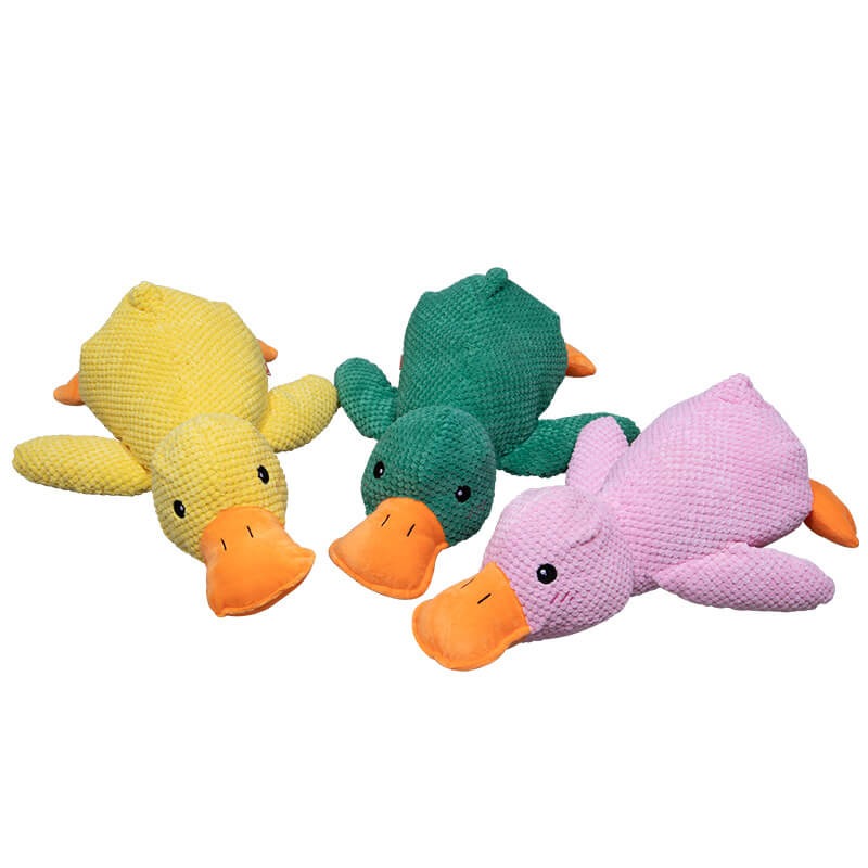 Yellow, green and pink calming duck dog toys together on a white background.