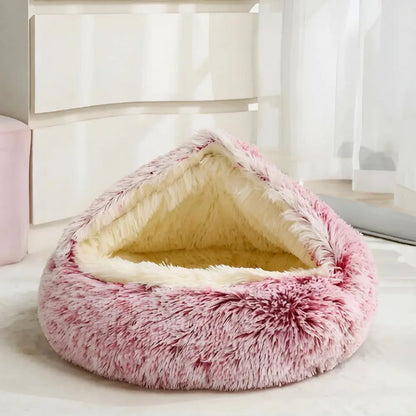 Pink Noblias calming hooded cave pet bed shown beside a bedroom window.