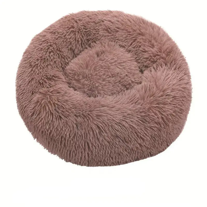 Tan long plush round calming dog bed on a white background