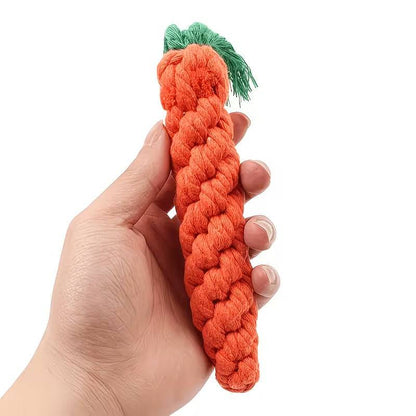 Hand holding the braided linen rope carrot dog toy with its green tassel top for size reference