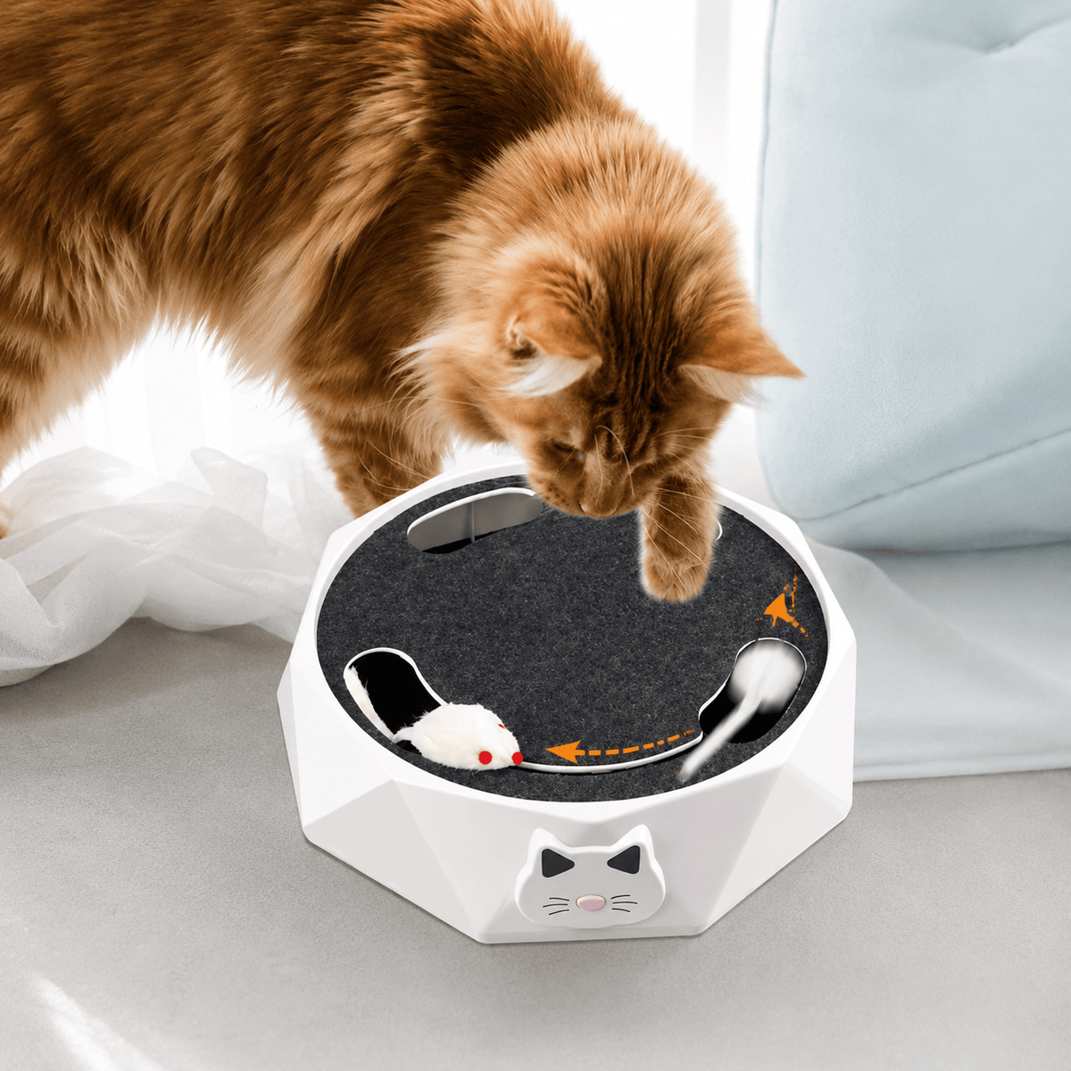 Orange cat pouncing on the plush mouse as it pops out of the white Noblias cat scratcher toy