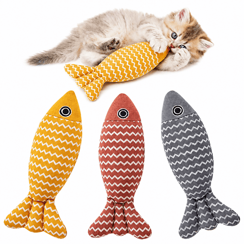 The three Noblias catnip fish kicker toys in yellow, red and gray linen, with a kitten hugging the yellow one.