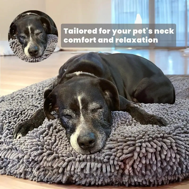 Black dog asleep in the gray chenille donut bed with its head resting on the raised rim