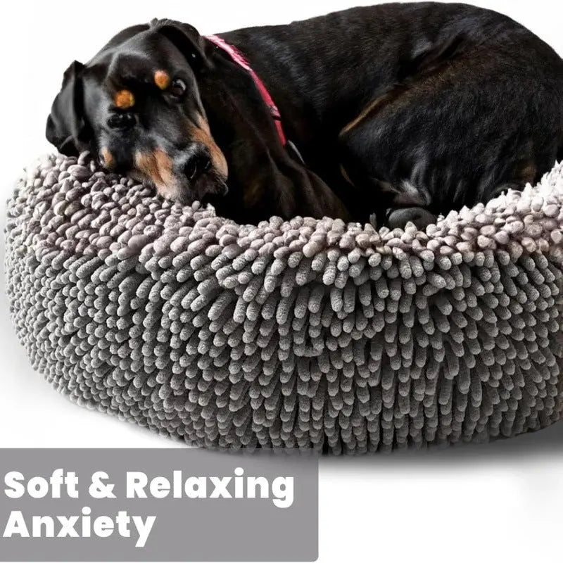 Dog curled tightly into the gray chenille donut bed with the bolster rim wrapped around it