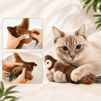Cat holding the brown sparrow cat toy between its front paws and kicking it with the back legs on a bed