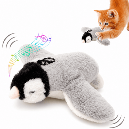 Penguin version of the Noblias chirping bird cat toy in black and white plush, with a ginger kitten reaching for it