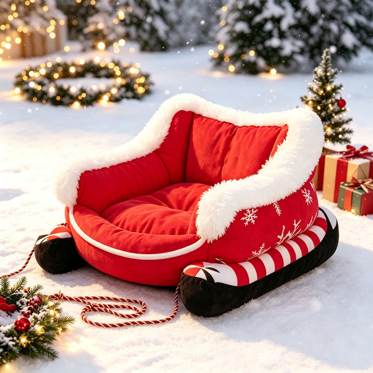Red Christmas sleigh pet bed with white faux fur trim and candy-cane runners sitting in the snow.