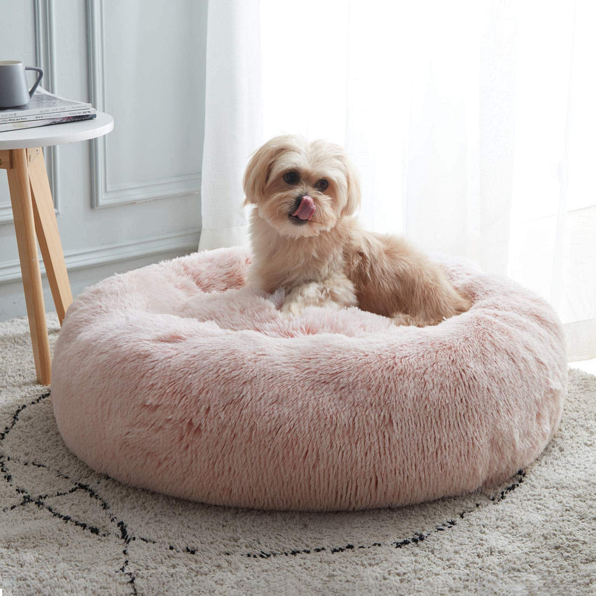 Pink Noblias cloud calming donut pet bed with a shih tzu sitting up in the middle.