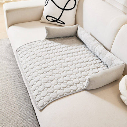 Gray Noblias cooling dog couch cover spread over a white sofa seat with the bolster back in place.