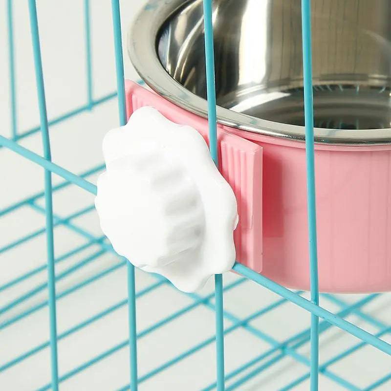 Pink crate bowl with its stainless steel insert clamped onto a blue cage wire, with the white hexagon nut tightened on the outside
