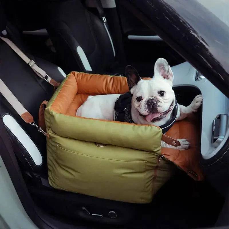 A french bulldog riding in the green Noblias dog car seat bed on the front passenger seat.