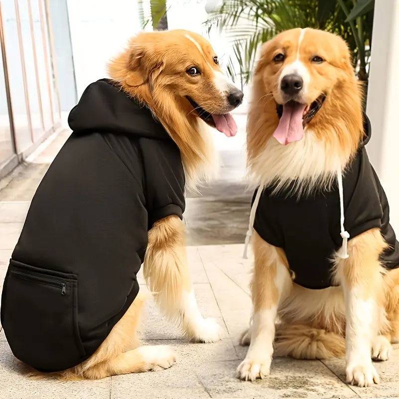 Two Golden Retrievers wearing black fleece dog hoodies outdoors, showing the hood and body fit