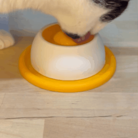 Animation of a cat licking the yellow dog lick bowl for small dogs.