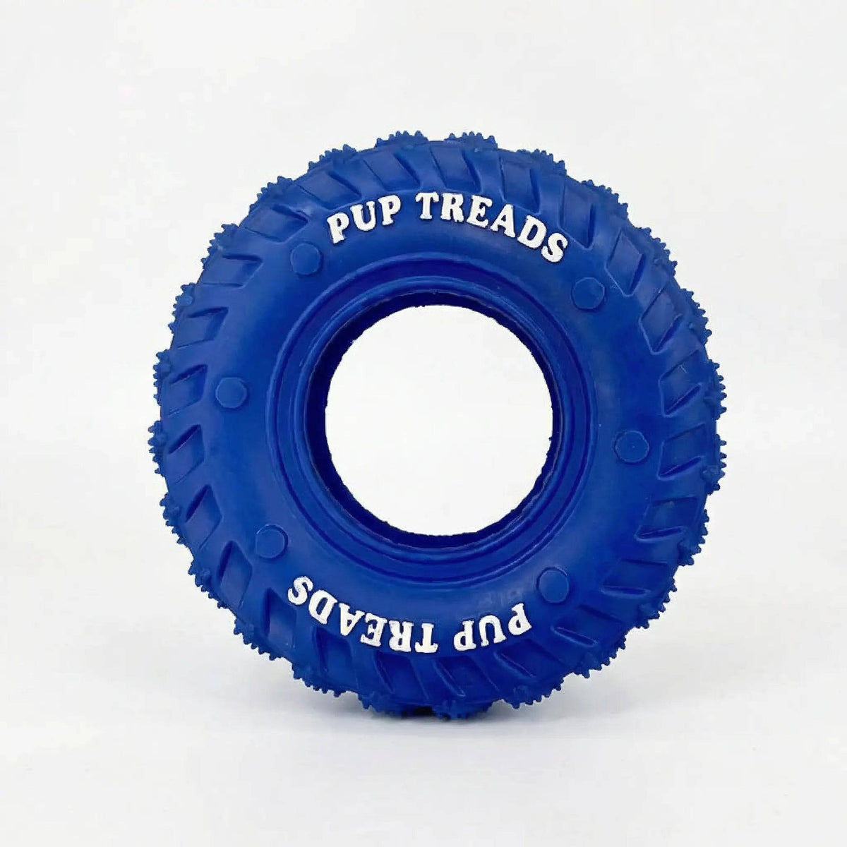The blue rubber dog tire chew toy on its own, showing the treaded outer surface and open center
