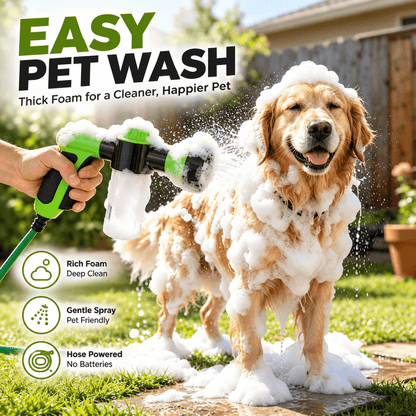 Golden retriever covered in foam being sprayed with the dog washing hose attachment in a backyard.