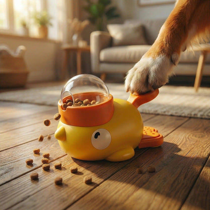 Dog's paw pressing the button on the yellow Noblias duck treat dispenser, with kibble scattered on the floor.