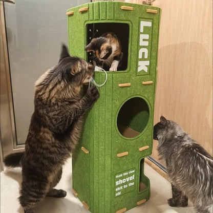 Two cats meeting at the upper opening of the green Noblias felt cat house while a third watches from below.