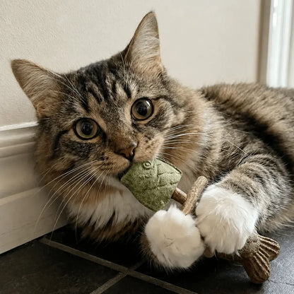 Tabby cat lying down and chewing the catnip head of the Noblias fish bone cat dental chew toy.