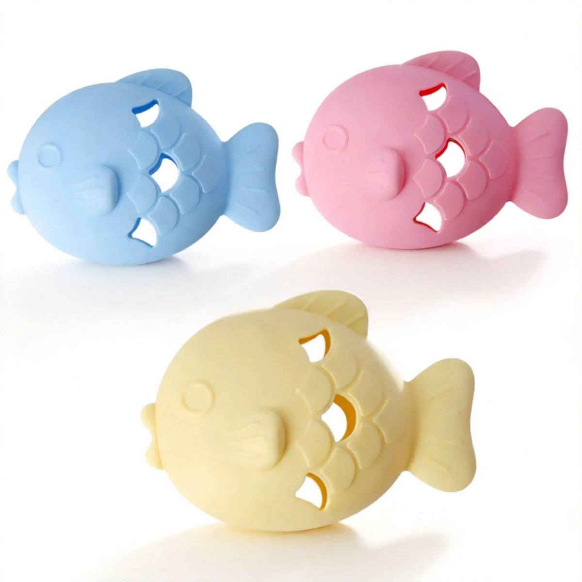 Three fish shaped silicone treat dispenser toys in blue, pink and light yellow with scale-shaped treat openings