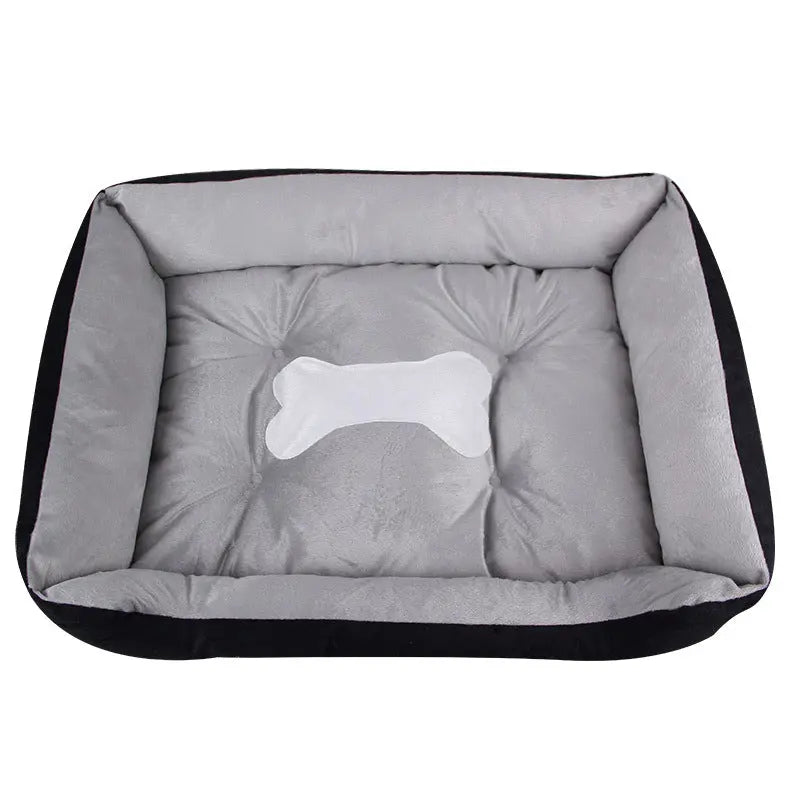 Black fleece bolster dog bed with a gray cushion and a white bone applique.