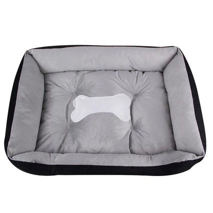 Black fleece bolster dog bed with a gray cushion and a white bone applique.