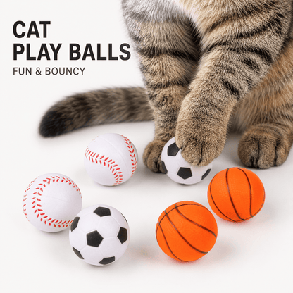 Tabby cat reaching a paw toward the soccer, baseball and basketball foam cat toy balls, labeled cat play balls, fun and bouncy.