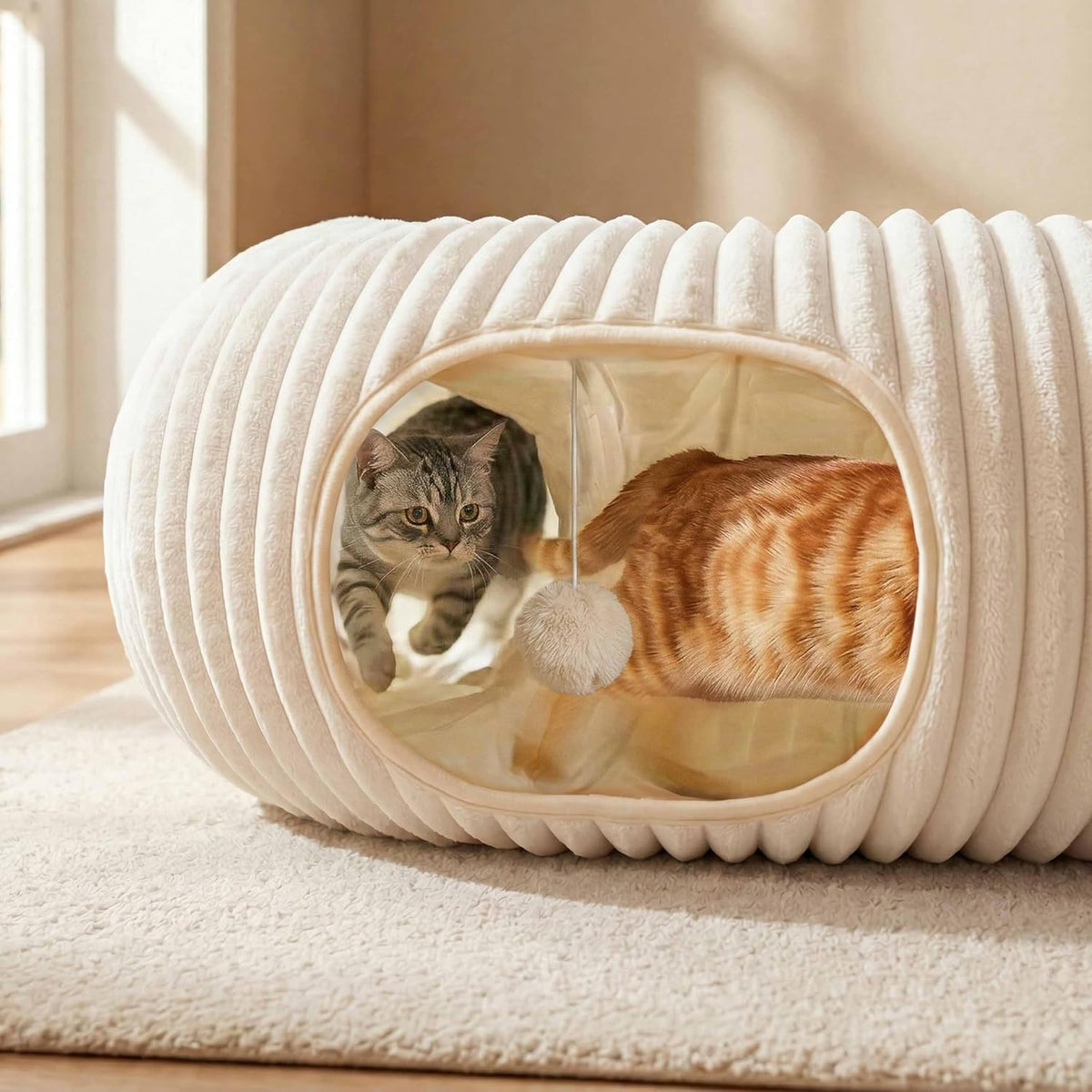 Two cats lying together inside the cream tunnel bed, showing how wide the tunnel is