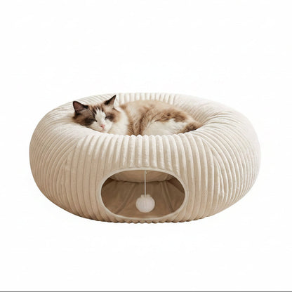 White cat tunnel bed in donut shape with the cushion in the middle, a tunnel opening and a hanging pom-pom ball