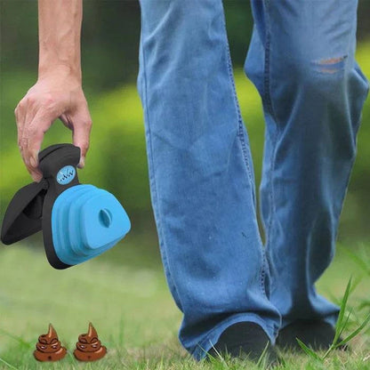 Hand holding the blue foldable pooper scooper open over the grass beside a person in jeans.