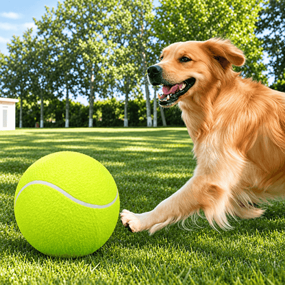 A golden retriever lying on the grass and pawing at the giant tennis ball for dogs.