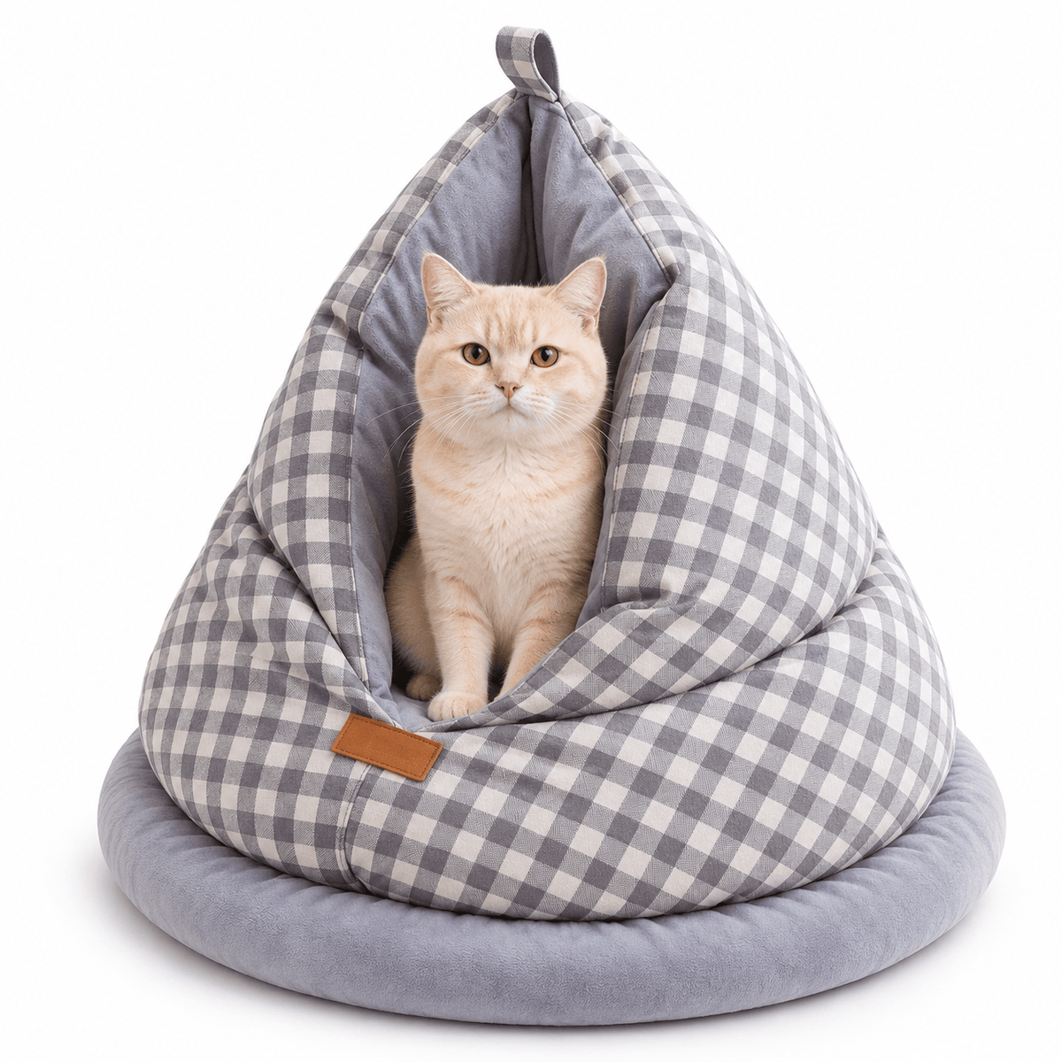 Cream cat sitting inside the gray gingham cat cave bed on a white background.