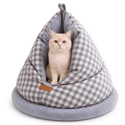 Cream cat sitting inside the gray gingham cat cave bed on a white background.