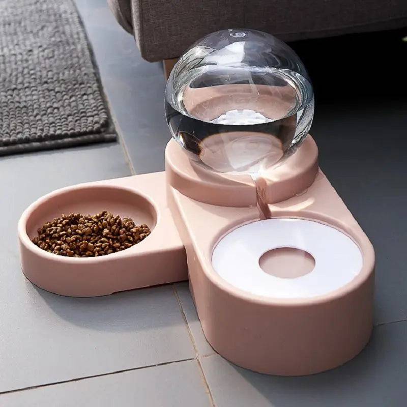 Close-up of the clear globe reservoir on the pink gravity water dispenser with the kibble bowl in front