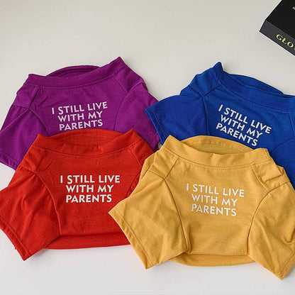Four I Still Live With My Parents dog shirts in purple, royal blue, red and yellow laid out together