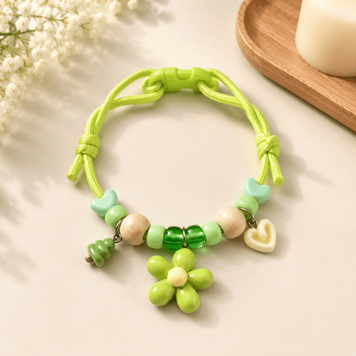 Green insect repellent pet collar with natural wood beads, a flower charm, a heart charm and a quick release buckle.