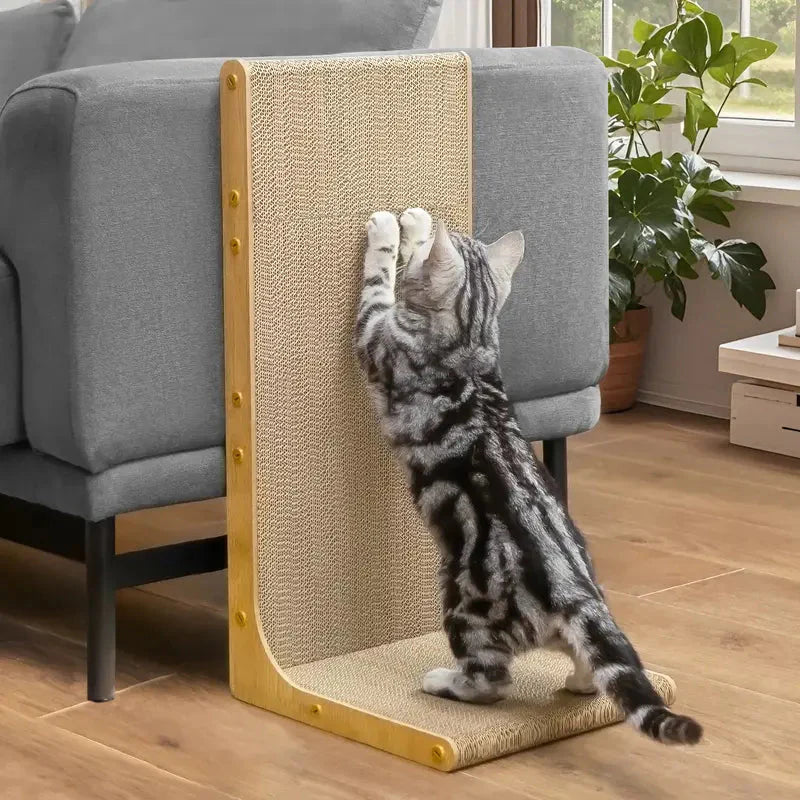Tabby kitten reaching full stretch on the Noblias L shaped sisal cat scratcher next to a gray sofa.