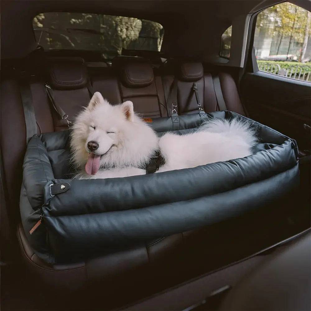 A samoyed resting in the gray Noblias large dog car seat bed laid flat in the trunk.