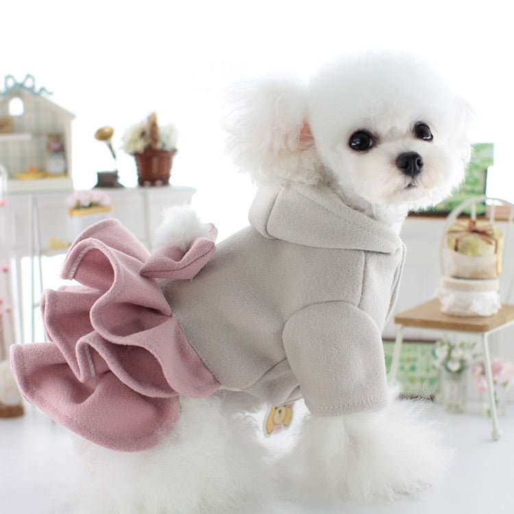 Small white dog wearing the layered dog dress with a hooded gray top and ruffle skirt